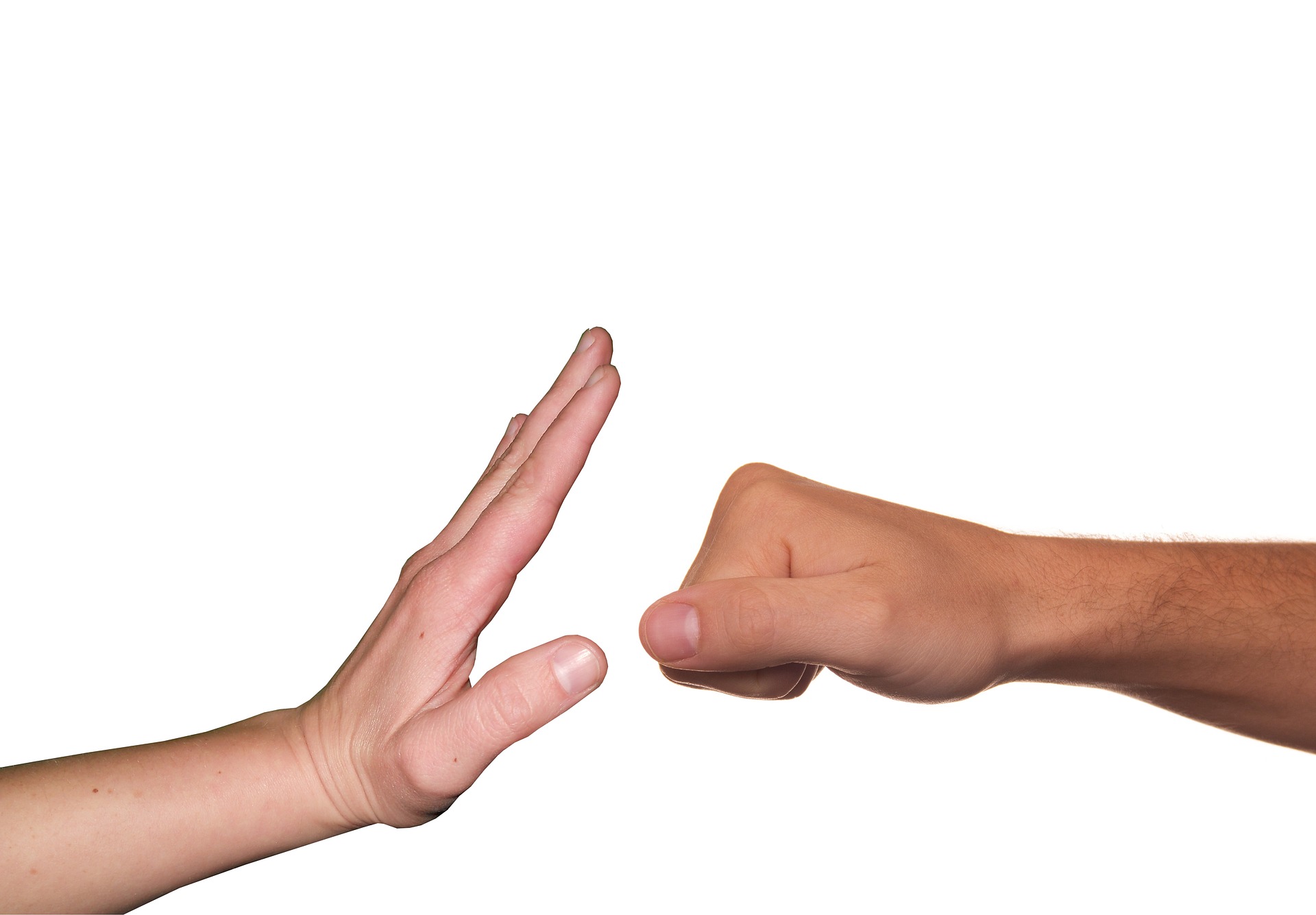 Zdjęcie przedstawia dwie dłonie (jedna otwarta, druga złożona w pięść) pokazujące gest sprzeciwu wobec przemocy fizycznej.